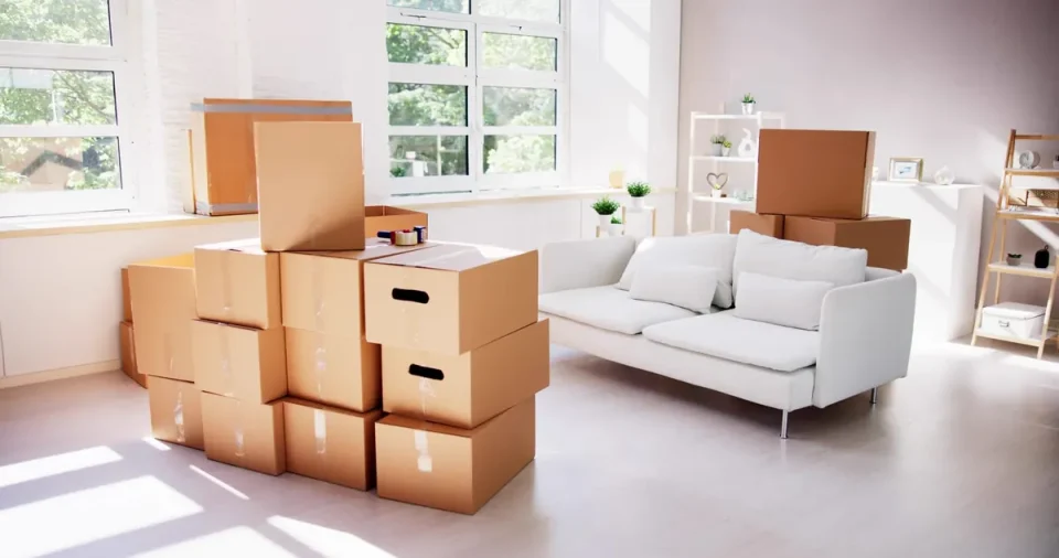 Packed boxes and furniture in an emptying living room during a probate clearance in Halsall